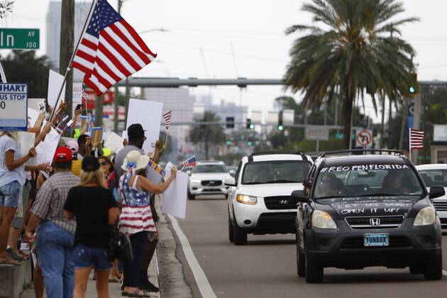April 26, 2020, Tampa, Florida, USA: Over 100 supporters of the Re-Open Florida CARavan and Rally movement gathered to protest in front of the FOX 13 News Station on Kennedy on Sunday, April 26, 2020 in Tampa. The group held signs, played music and spread their message to reopen the state of Florida after being closed for months. Tampa USA - ZUMAs70_ 20200426_zan_s70_008 Copyright: xLuisxSantanax
