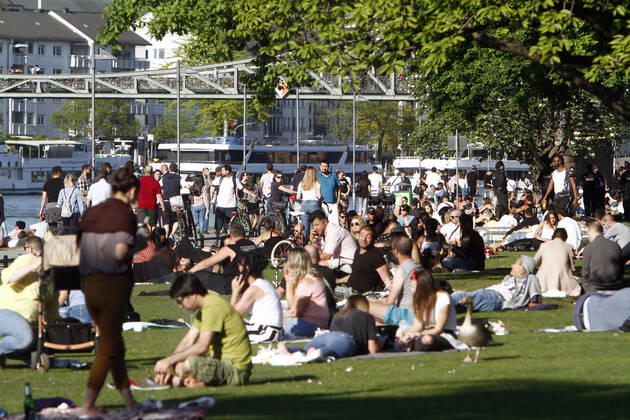 Sonnenhungrige in großer Zahl genießen trotz Coronavirus-Krise, Ausgangsbeschränkungen und Kontaktverboten die warmen Temperaturen und die Sonnenstrahlen auf einer Liegewiese am Mainufer in der Innenstadt Frankfurt und halten nicht immer den Mindestabstand ein; Hessen, Deutschland