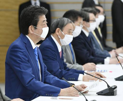 New coronavirus Japanese Prime Minister Shinzo Abe (L) attends a meeting of the government task force on combatting the new coronavirus pandemic in Tokyo on April 27, 2020. 