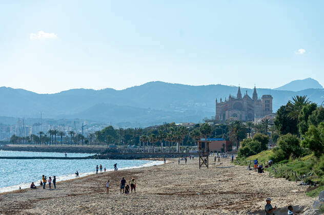 20200426 Children go out of the Home in Mallorca during Corona Lock down PALMA DE MALLORCA, SPAIN - APRIL 26 2020 : Palma Beach view to the Cathedral with families enjoying sun on the beach at - Children go out of the Home in Mallorca during Corona Lock down on April 26, 2020 in Palma de Mallorca, . Palma de Mallorca Baleares Spain