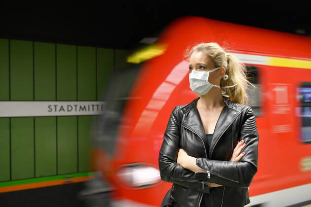 Frau mit Mundschutzmaske, wartet auf Zug, S-Bahn, Corona-Krise, Stuttgart, Baden-Württemberg, Deutschland Coronavirus