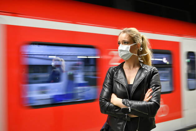 Frau mit Mundschutzmaske, wartet auf Zug, S-Bahn, Corona-Krise, Stuttgart, Baden-Württemberg, Deutschland Coronavirus