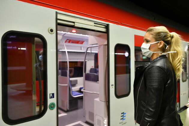Frau mit Mundschutzmaske, wartet auf Zug, S-Bahn, Corona-Krise, Stuttgart, Baden-Württemberg, Deutschland Coronavirus