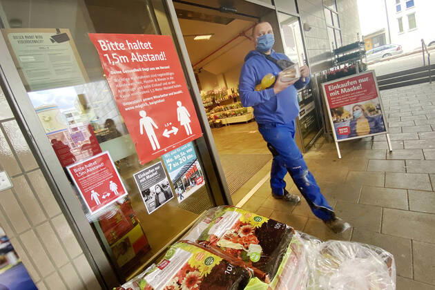 Lockerungen und Maskenpflicht in der Coronavirus Pandemie: Geschaefte in Bayern oeffnen am 27.April wieder. Ein Schild weist auf das Tragen von Mund Nasenschutz hin.Maskenpflicht.Mund-Nase-Schutz. REWE Supermarkt Ladengeschaeft ,Filiale,Eingang,