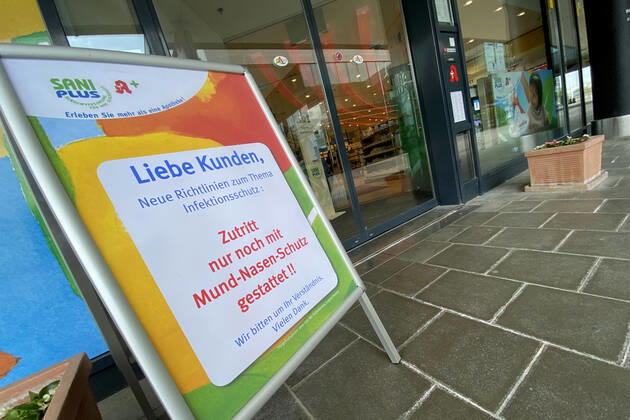 Lockerungen und Maskenpflicht in der Coronavirus Pandemie: Geschaefte in Bayern oeffnen am 27.April wieder. Hinweis,Aufsteller vor einer Sani Plus Apotheke: Zutritt nur noch mit Mund-Nasen-Schutz gestattet. Ladengeschaeft ,Filiale,Eingang,