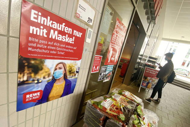 Lockerungen und Maskenpflicht in der Coronavirus Pandemie: Geschaefte in Bayern oeffnen am 27.April wieder. Ein Schild weist auf das Tragen von Mund Nasenschutz hin.Maskenpflicht. REWE Supermarkt Ladengeschaeft ,Filiale,Eingang,