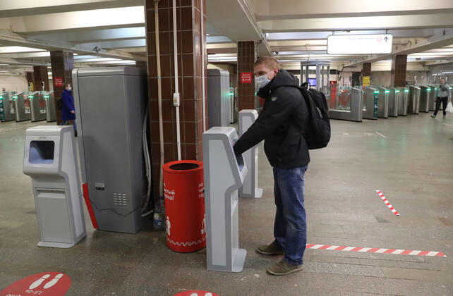 MOSCOW, RUSSIA - APRIL 27, 2020: A commuter in a face mask uses a contactless hand sanitiser machine at the entrance to a deserted Komsomolskaya Station of the Moscow Underground (metro), during the pandemic of the novel coronavirus disease (COVID-19). Since 30 March, Moscow has been on lockdown. On 13 April 2020, the Moscow government introduced a digital permit system aimed at further restricting movement. Under the scheme, which became mandatory on 15 April, people need to apply for permits to travel on a vehicle or public transport around the city. As of 27 April 2020, Russia has reported more than 87,300 confirmed cases of the novel coronavirus infection, with more than 45,300 confirmed cases in Moscow. Vladimir Gerdo TASS  TS0D7337