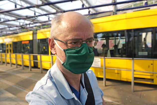 Maßnahmen gegen das Coronavirus Ein Mann trägt einen dichten grünen und professionell genähten Mundschutz für eine Fahrt mit der Straßenbahn Essen Nordrhein-Westfalen Deutschland