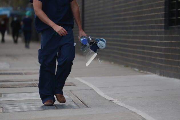 April 27, 2020, New York, NY, USA: The evening shift of nurses, doctors and other medical workers arrive at Elmhurst Hospital in Queens, New York City to treat COVID-19 and novel Coronavirus patients. Close-up of hand of medical worker holding PPE mask and face shield. New York USA - ZUMAh16_ 20200427_zaf_h16_021 Copyright: xDanxHerrickx