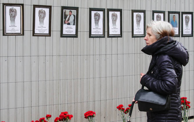 ST PETERSBURG, RUSSIA - APRIL 28, 2020: A woman by portraits of medical workers who died after contracting the novel coronavirus by the offices of St Petersburg s Healthcare Committee in Malaya Sadovaya Street. The wall of memory was created by St Petersburg resident Irina Maslova. Peter Kovalev TASS  TS0D7523