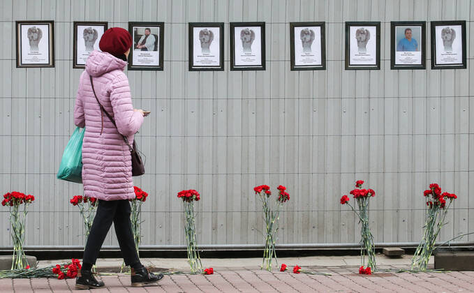 ST PETERSBURG, RUSSIA - APRIL 28, 2020: A woman by portraits of medical workers who died after contracting the novel coronavirus by the offices of St Petersburg s Healthcare Committee in Malaya Sadovaya Street. The wall of memory was created by St Petersburg resident Irina Maslova. Peter Kovalev TASS  TS0D7525