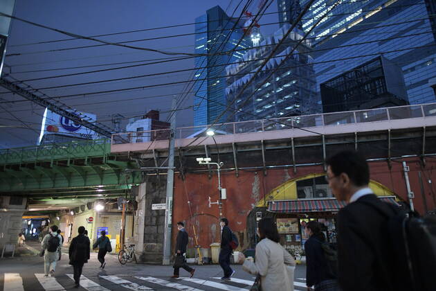 TOKYO, JAPAN - APRIL 28: Commuters wearing face masks head back home after work in Tokyo s financial district amid concerns of the COVID-19 coronavirus outbreak on Tuesday, April 28, 2020. Japanese Prime Minister Shinzo Abe declared a nationwide State of Emergency last week urging people to stay home to prevent the spread of the coronavirus throughout the country. (Photo: Richard Atrero de Guzman AFLO) (125786476)