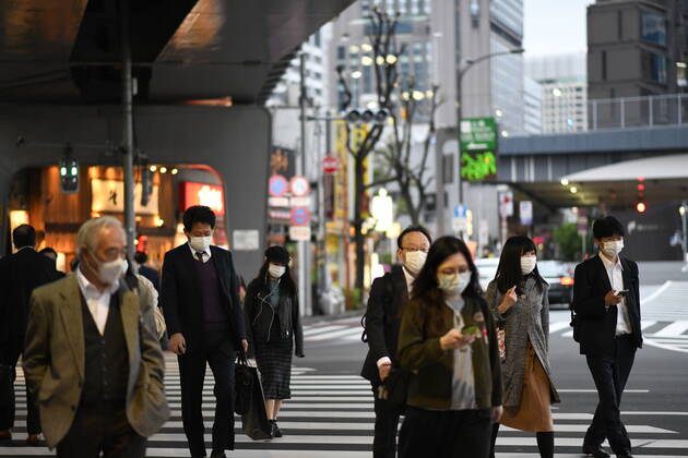 TOKYO, JAPAN - APRIL 28: Commuters wearing face masks heading back home after work in Tokyo s financial district amid concerns of the COVID-19 coronavirus outbreak on Tuesday, April 28, 2020. Japanese Prime Minister Shinzo Abe declared a nationwide State of Emergency last week urging people to stay home to prevent the spread of the coronavirus throughout the country. (Photo: Richard Atrero de Guzman AFLO)  (125786520)