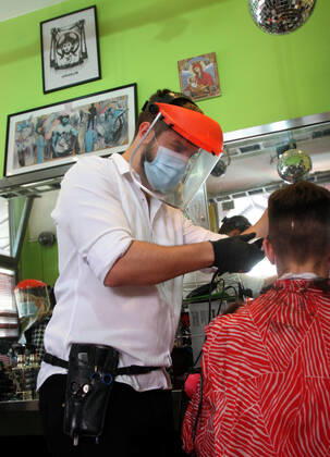 28.04.2020 Belgrade(Serbia) Coronavirus Covid-19 Life loosening measures Friseur hair stylist studio Goca Gotza open after 43 days state of emergency.Friseour hairdresser Nikola working with protection mask,vizir visor made of plexiglass.