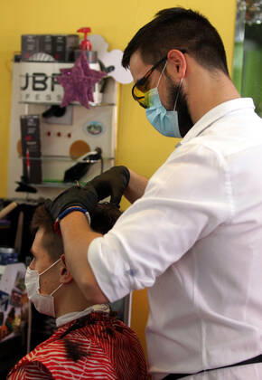 28.04.2020 Belgrade(Serbia) Coronavirus Covid-19 Life loosening measures Friseur hairdresser studio Goca Gotza open after 43 days state of emergency.Friseour hairdresser Nikola working with protection mask,gloves and glasses. 