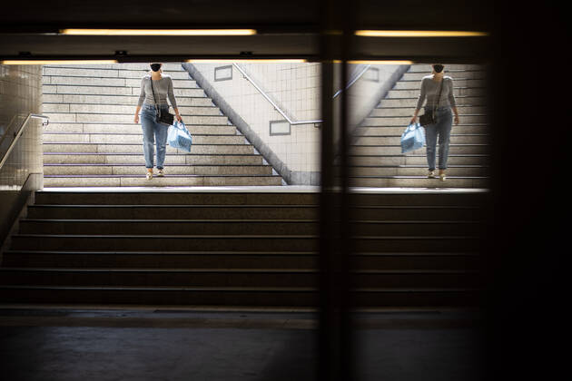 Eine Frau mit Mundschutz betritt die U-Bahnstation in Berlin, 28.04.2020. Deutschlandweit gibt es eine Maskenpflicht im Oeffentlichen Personennahverkehr. Berlin Deutschland