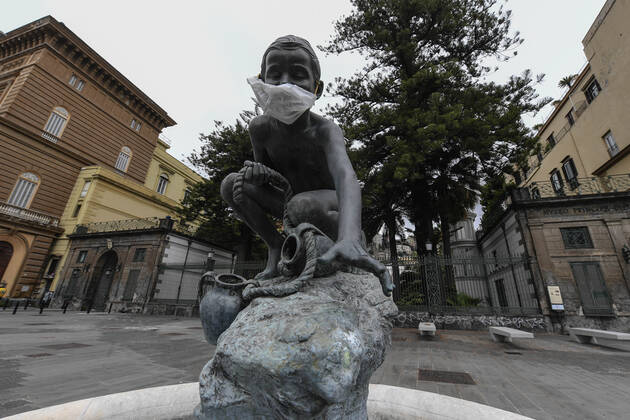 A protective mask is placed on a statue of a child fisherman, in street riviera, in Naples city. Government Decree declaring all of Italy a protected area to combat Covid-19 - Coronavirus infection.  Copyright: xSalvatorexLaportax xIPAx xKontrolabx