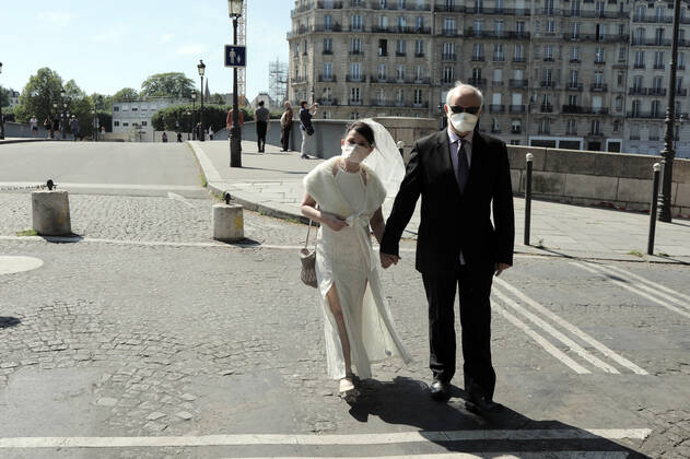 News Bilder des Tages A couple celebrating their wedding anniversary wear masks as they take a stroll in the near empty streets of Paris, France, Tuesday April 28, 2020. The French premier announced today that protective masks, which have been in severe shortage since the outbreak of the pandemic, will be available for everyone starting May 11th.  PAR20200428105 ECOxCLEMENT