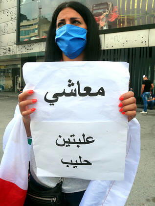 April 27, 2020, Beirut, Beirut, Lebanon: Lebanese protester Anti-government holds a Banner during a protest against growing economic hardship in Beirut, Lebanon April 28, 2020. Hundreds of protesters in Lebanon s northern city of Tripoli set fire to two banks and hurled stones at soldiers, who responded with tear gas and batons in renewed clashes triggered by an economic crisis spiraling out of control amid a weeks-long virus lockdown Beirut Lebanon - ZUMAap3_ 20200427_zaf_ap3_207 Copyright: xHaithamxAl-Mousawix