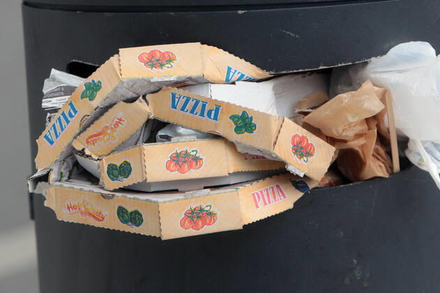 Pizza Schachteln stapeln sich nach einem Außer Haus Verzehr in einem überfüllten Mülleimer in der Innenstadt von Mannheim, Baden Württemberg, Deutschland