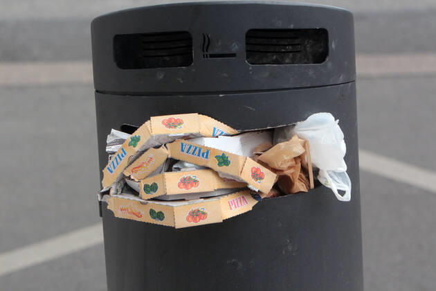 Pizza Schachteln stapeln sich nach einem Außer Haus Verzehr in einem überfüllten Mülleimer in der Innenstadt von Mannheim, Baden Württemberg, Deutschland
