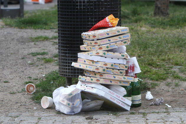 Pizza Schachteln stapeln sich nach einem Außer Haus Verzehr neben geleerten Sektflaschen vor einem überfüllten Mülleimer in der Altstadt von Köln, Nordrhein Westfalen, Deutschland