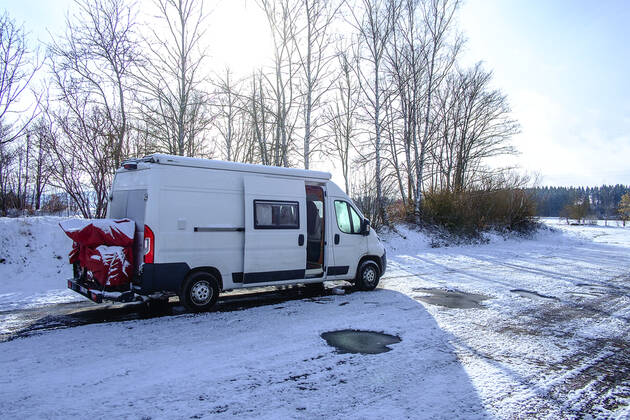 Ein Camperbus steht auf einem Parkplatz im Neuschnee, Donaueschingen, Baden Württemberg, Deutschland. Wohnmobil im Winter