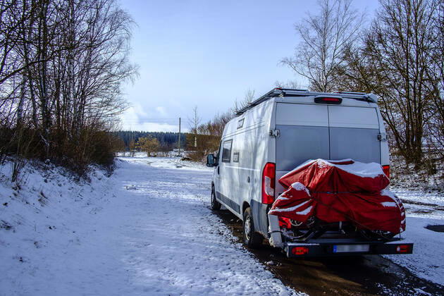 Ein Camperbus steht auf einem Parkplatz im Neuschnee, Donaueschingen, Baden Württemberg, Deutschland. Wohnmobil im Winter