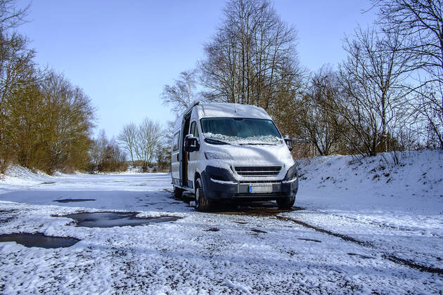 Ein Camperbus steht auf einem Parkplatz im Neuschnee, Donaueschingen, Baden Württemberg, Deutschland. Wohnmobil im Winter