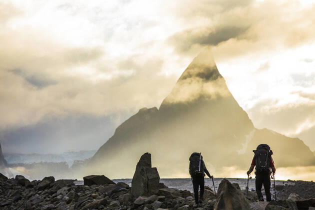 Rear view of backpackers approaching dramatic mountain, Mt. Loki Pangnirtung, NU, Canada CR_JDIP200518-319442-01,model released, Symbolfoto