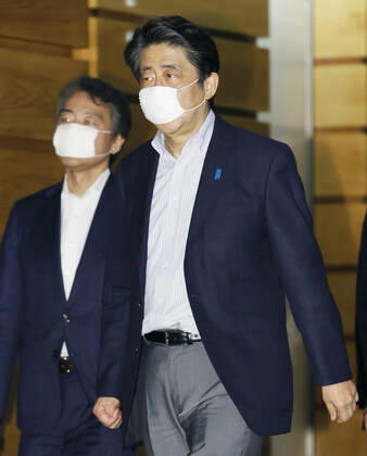 Japan PM Abe Japanese Prime Minister Shinzo Abe leaves his office in Tokyo on June 14, 2020, wearing a face mask amid continuing worries over the novel coronavirus.