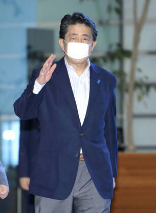 Japan PM Abe Japanese Prime Minister Shinzo Abe arrives at his office in Tokyo on June 20, 2020, wearing a face mask amid continued worries over the novel coronavirus.