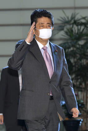 Japan PM Abe Japanese Prime Minister Shinzo Abe arrives at his office in Tokyo on June 24, 2020, wearing a face mask amid concerns over a possible second wave of coronavirus infections in the country.
