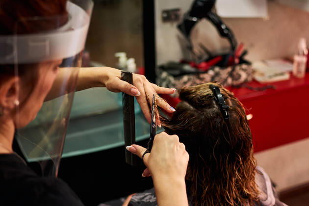 A close-up of a hairdresser cutting client s hair with a face shield Villena, Valencian Community, Spain CR_CRBL200605-417586-01 ,model released, Symbolfoto