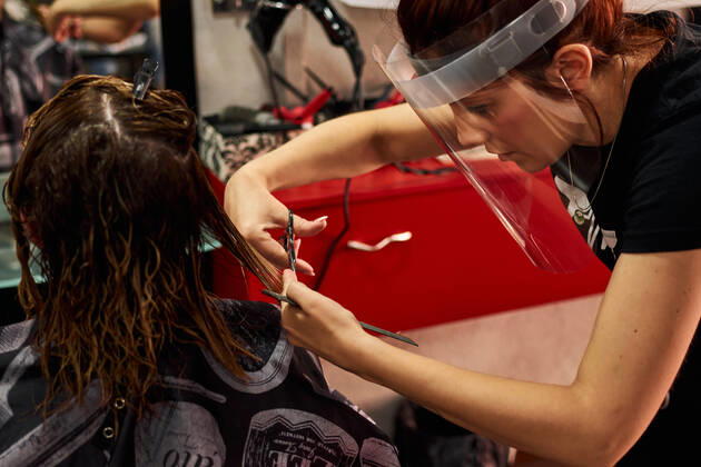 A close-up of a hairdresser cutting client s hair with a face shield Villena, Valencian Community, Spain CR_CRBL200605-417612-01 ,model released, Symbolfoto