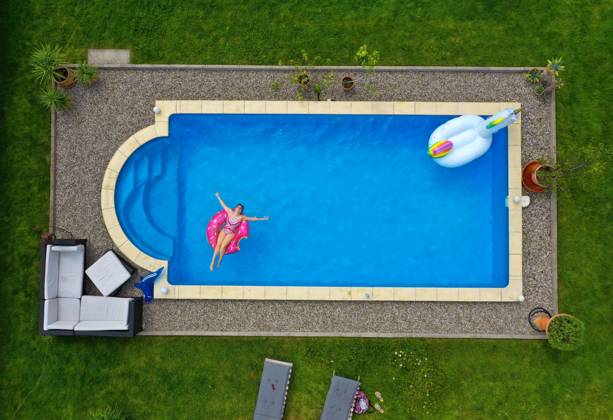 26.06.2020, Trend in der Corona-Pandemie: Der eigene Swimmingpool im Garten sorgt im Sommer für Erfrischung wenn die Freibäder geschlossen haben. Luftaufnahme eines Gartenpools im Unterallgäu. Teenager sonnt sich auf einem Schwimmreifen im Wasser. (Modelreleased) 26.06.2020, Swimmingpool im eigenen Garten 26.06.2020, Swimmingpool im eigenen Garten