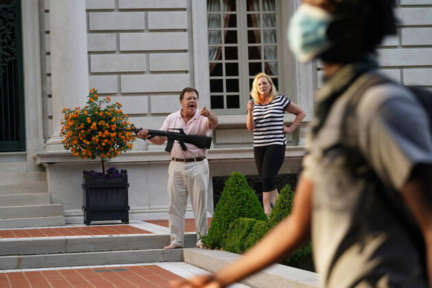 Bilder des Jahres 2020, News 06 Juni News Themen der Woche KW26 A husband and wife hold a pistol and semi-automatic rifle as protesters walk past their house en route to St. Louis Mayor Lyda Krewson s home during a protest march in St. Louis on Sunday, June 28, 2020. The man and woman greeted about 300 protesters, shouting as they broke down a gate in the neighborhood to march past their home. No shots were fired and the protesters moved on.  SLP2020062824 BILLxGREENBLATT