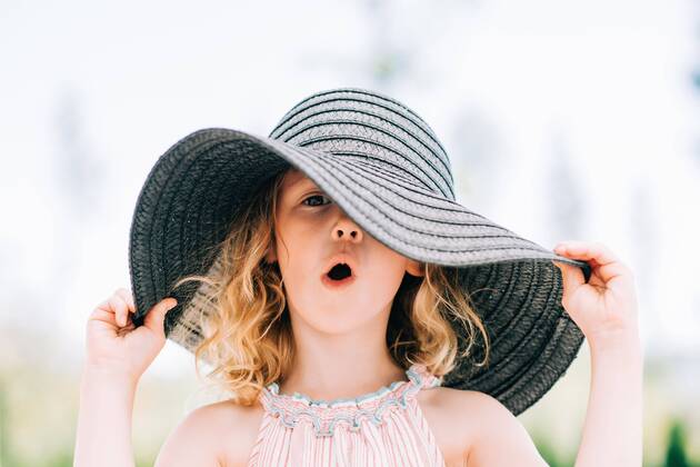 Creative Highlights Symbolfotos portrait of a young girl pulling a funny expression with a sun hat on Norrtälje, Stockholm County, Sweden CR_RABE200701-430685-01 ,model released, Symbolfoto