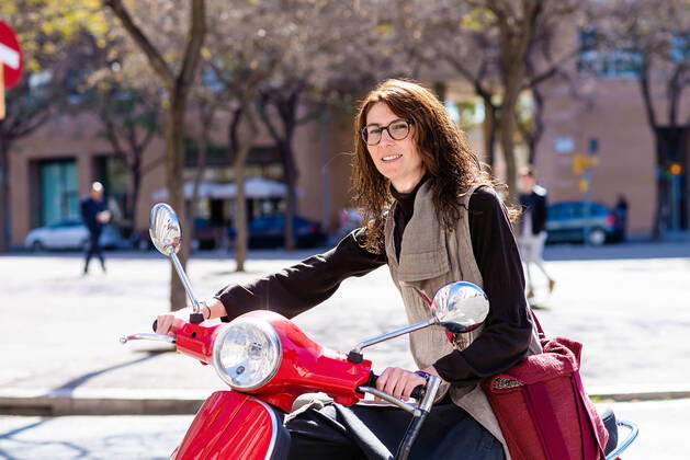 Happy cheerful girl driving scooter through city street. Barcelona, CT, Spain CR_RAFE200708-384970-01 ,model released, Symbolfoto