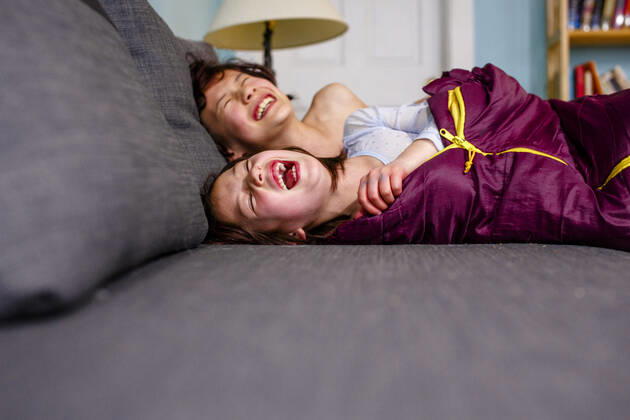 two happy children lay on couch together laughing out loud with joy Columbus, OH, United States CR_RETI200701A-380927-01 ,model released, Symbolfoto