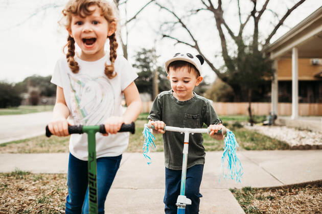 Young sister and brother riding scooters outside in front yard Fort Worth, TX, United States CR_TAHI200701-413913-01 ,model released, Symbolfoto
