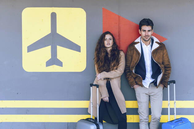 Confident business couple standing with luggage at airport terminal model released Symbolfoto EHF00430
