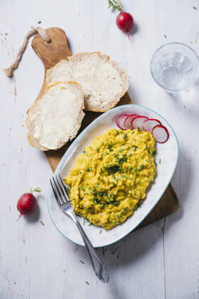 Plate of vegan scrambled eggs with chick-peas, chive, radish and bread IPF00541