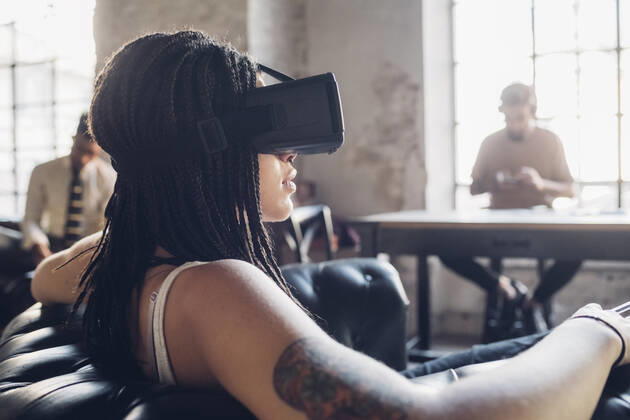 Young woman relaxing in armchair in loft office wearing Vr goggles model released Symbolfoto property released MEUF00736