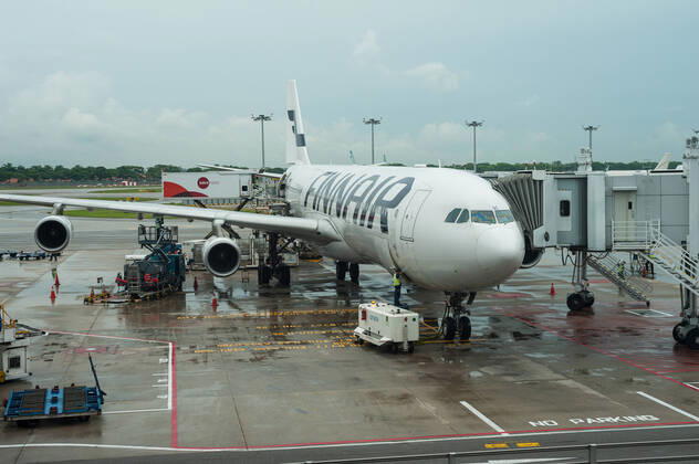 11.06.2016, Singapur, Republik Singapur, Asien - Ein Airbus A340-300 Passagierflugzeug der Finnair an einem Flugsteig am Terminal 1 auf dem Flughafen Changi. Finnair ist Mitglied im Verbund der One World Airline-Allianz.