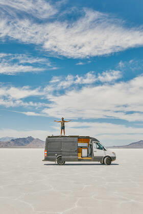 Young man standing on roof of camper van in Bonneville Salt Flats. Salt Lake City, UT, United States CR_JUSLKY200806-466993-01 ,model released, Symbolfoto ,property released