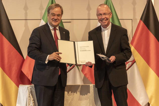 Verleihung des Landesverdienstordens Nordrhein-Westfalen am 23. August 2020 in der Flora Köln. Ordensträger Monsignore Peter Kossen erhält von NRW-Ministerpräsident den Orden überreicht. Kossen kämpft seit Jahren gegen menschenunwürdige Arbeitsbedingungen für Menschenwürde und Gerechtigkeit. Laschet zeichnete am 23. August 2020 in der Flora in Köln vierzehn Persönlichkeiten für ihr außerordentliches Engagement für die Gesellschaft mit dem Verdienstorden des Landes Nordrhein-Westfalen aus. Köln Nordrhein-Westfalen Deutschland