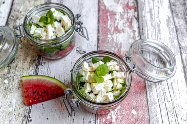 Watermelon slice and jars of watermelon salad with feta cheese, corn salad and mint SARF04608