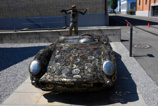 Schweiz, Romanshorn, 12.08.2020 Die autobau erlebniswelt ist ein aussergewoehnliches Automuseum in der Schweiz. Die einzigartige Sammlung des Schweizer Rennfahrers Fredy Lienhard fokussirt sich auf Sportwagen und zeigt rund 90 von weit mehr als 100 vorhandenen Fahrzeugen. Foto: die Stahlskulptur Porsche 550 Spider, mit der Stahlskulptur James Dean, vor dem Museum Das Automuseum autobau erlebniswelt in der Schweiz