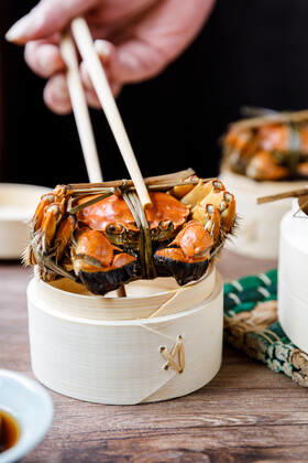 Chinese traditional cuisine in a steamer steamed Yangcheng Lake hairy crabs and seasoned vinegar ginger shreds in a dish. 779640030049599565